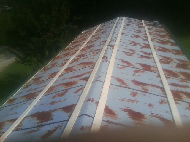 Rusted metal roof panels with new wood purlins before replacement — Storm Damage Roof Repair in Chittenango by Roofing Brothers